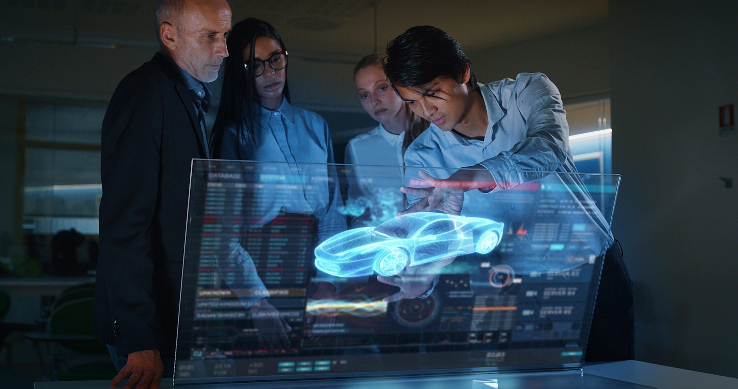 A group of modern engineers are designing an electric car by using futuristic sophisticated technology screen with augmented reality holograms in a creative studio.